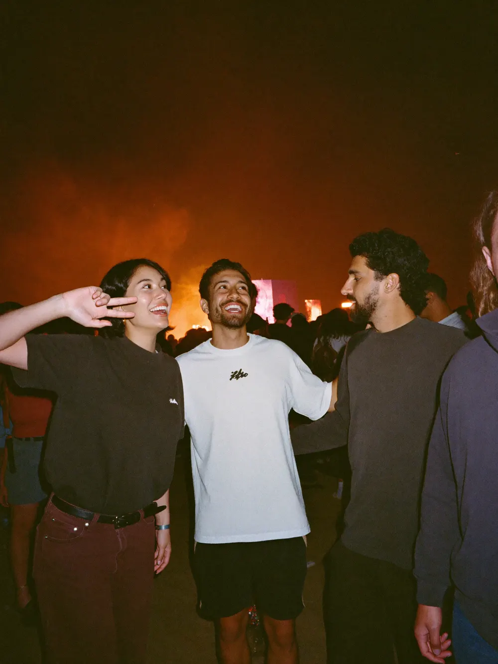 Three friends laughing at a festival at night